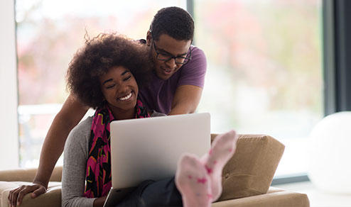 Image of young man and woman looking at laptop.
